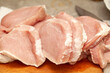 Lots of uncooked fresh juicy raw fat pork chop meat pieces, freshly cut up, food, object closeup, nobody. Unprocessed pig meat, raw chops set, loin cuts up close, kitchen scene, nutrition concept