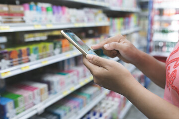 person use mobile phone in supermarket.
