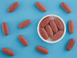 Organic red yeast rice tablets in a cap with other organic red yeast rice tablets around them