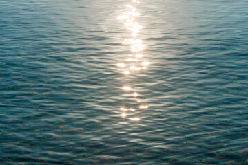 Detail of a sunlight reflecting in glittering sea. sparkler in water - background. sea water with sun glare and ripple. Powerful and peaceful nature concept