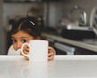 © cemmustafa - Mug Mockup. white blank sublimation cup mockup. little girl child holding mug in kitchen. Image available to mug vendors and designers. suitable for the use of mug printing and cup companies