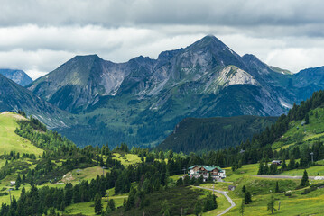 Sunny mountain landscape - meadows, forest, ski lifts, houses, roads,  in alpen ski resort Obertauern in summer, Radstadter Tauern, Austria.