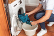 © Samuel Perales - a man taking a blue sweatshirt out of the washing machine