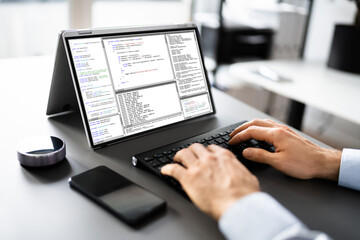 Computer Programmer Writing Program Code On Computer