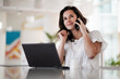 © shellygraphy - remote working dark haired woman calling and chatting infront of a laptop or notebook in casual outfit on her work desk in her modern airy bright living room home office with her mobile phone