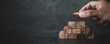 © Jintana - Hand place wooden block stack in pyramid stair step concept of prevent collapse or crash of financial business and risk management or strategic planning and insurance.