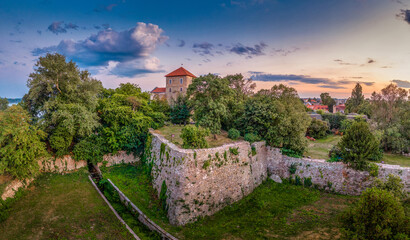 Wall Mural - Aerial closeup view of medieval Tata water castle on the old lake with sunset colorful sky, ramparts, Kecske bastion for hosting gun platforms, Gothic inner castle in Komarom county Hungary