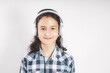 © yusev - Portrait of a positive smiling teenage girl. Cute pretty girl in white headphones on a white background. Copy space. Teenager stock photo