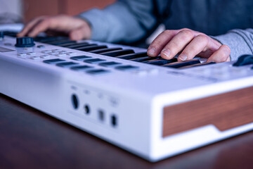 Wall Mural - Close-up, male hands are playing the midi keyboard.