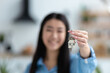 © kucherav - New home new life. Asian young woman feels very ecstatic about their recent purchase of a new home or rented apartment. Satisfied homeowner. Female holding key of dwelling