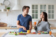 © BestForYou - Romantic young couple cooking together in the kitchen having a great time together.