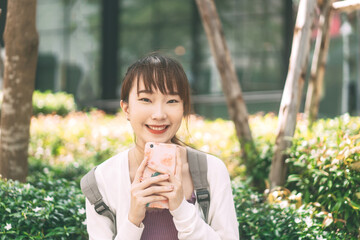 Wall Mural - Portrait of happy smile young adult asian student woman with backpack at outdoor on day.