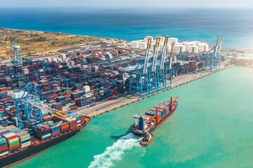 Wall Mural - Aerial view of a huge port with containers and cargo ships entering the port for loading and unloading.