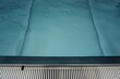 Blaues Schwimmbecken mit Wasser und Beckenrand im Sommer