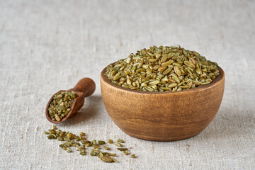 Uncooked cracked freekeh grain in wooden bowl . Closeup