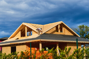 A worker building a passivhaus house with wood