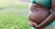Close up pregnant belly of young African woman in park - Maternity lifestyle concept