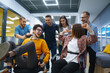 © maxbelchenko - Young cheerful business people  having fun while racing on office chairs and smiling. Friendly work team enjoying fun work break activities.