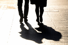 People Walking The Street, Close Up Of Backlit Legs, Shadows