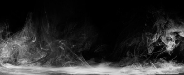 Wall Mural - Abstract colored smoke moves on black background. Mystical swirling smoke rolling low across the ground.