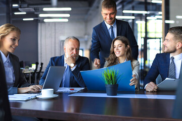 Group of business partners discussing ideas and planning work in office.