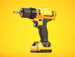 Yellow electric screwdriver drill  on yellow background