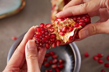 Wall Mural - fresh pomegranate seeds in hand 