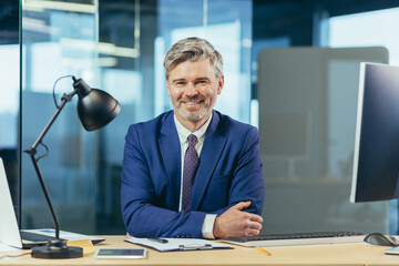 Wall Mural - Portrait of successful seo boss, businessman at work, working on computer in modern office, looking at camera, happy and smiling