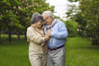 © Studio Romantic - Portrait of cheerful loving married senior couple hugging in city park. Retired mature man and woman grandparent embracing holding hands showing love and adoration. Happy retirement and relationship