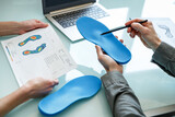 Fototapeta Przestrzenne - Doctor consulting patient on custom orthotic insoles in a clinic for a personalised custom fit.