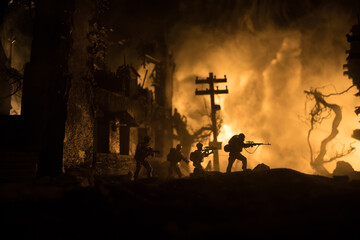 War Concept. Military silhouettes fighting scene on war fog sky background, World War Soldiers Silhouette Below Cloudy Skyline At night. Battle in ruined city.