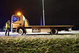 Fototapeta  - Samochód pomocy drogowej podczas obsługi wypadku drogowego w nocy na drodze. 