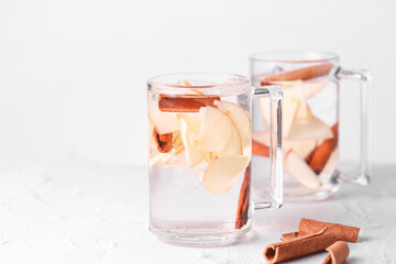 detox drink with apple cinnamon and ice stands on a light background in glass glasses