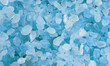 Blue salt crystals as background photo. Closeup blue ice stones lay on a flat surface. Rectangular area of icy crystals. Natural gemstone minerals lie in rectangle background. Photo of salty stones.