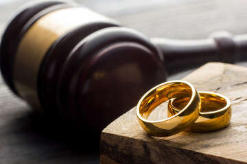 Wall Mural - Divorce and separation concept. Two golden wedding rings, judge gavel.