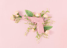 Pastel Pink Gun With Blooming Rose Flowers And Leaves On Bright Pink Background. Minimal Peace Concept. Creative Floral Spring Composition. Flat Lay.