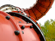 Selective Focus On The Articulation Fragment Of The Elements Of A Large Red Curved Pipe For Riding On The Children's Playground.