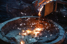 Liquid Cast Iron Is Poured Into The Ladle In A Thin Stream. Lots Of Sparks.