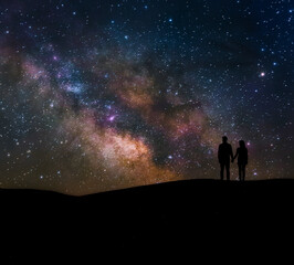 Wall Mural - The beautiful shot of the couple silhouette with the  star night background