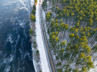 Poster - Aerial view of road along forest and river after winter snow