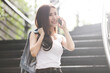 Young and beautiful Asian freelance business woman using a smart phone while walking on the stairs in the urban city 