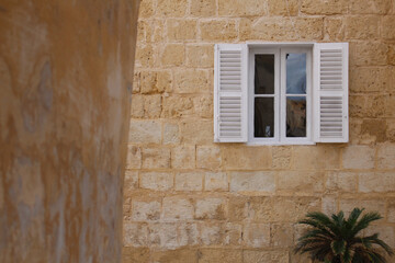 Poster - An exterior view of an old building with white windows