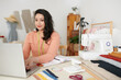 © DragonImages - Smil seamstress answering e-mails from clients when working on computer in her studio