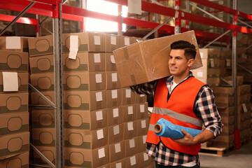 Poster - Worker with roll of stretch film and wrapped box in warehouse