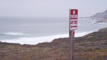 No Parking Any Time Road Sign On Pacific Coast Highway 1 Or Cabrillo Road. Sea Waves On Garrapata Beach, California Big Sur Nature Trail, USA. Mountains, Foggy Misty Weather. Tourist Route Along Ocean