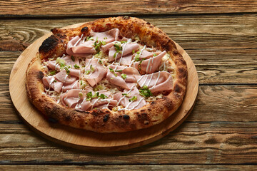 Wall Mural - Fresh pizza with ham and pineapple on wooden table in restaurant.