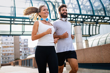 Wall Mural - Happy runner couple exercising outside as part of healthy lifestyle. People sport running concept