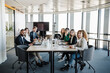 © Westend61 - Smiling businesswomen and businessmen sitting together in board room