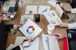 © Westend61 - Businessmen and businesswomen with graphs and charts planning strategy together in office