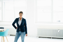 Confident Businesswoman With Hand On Hip Standing At Office